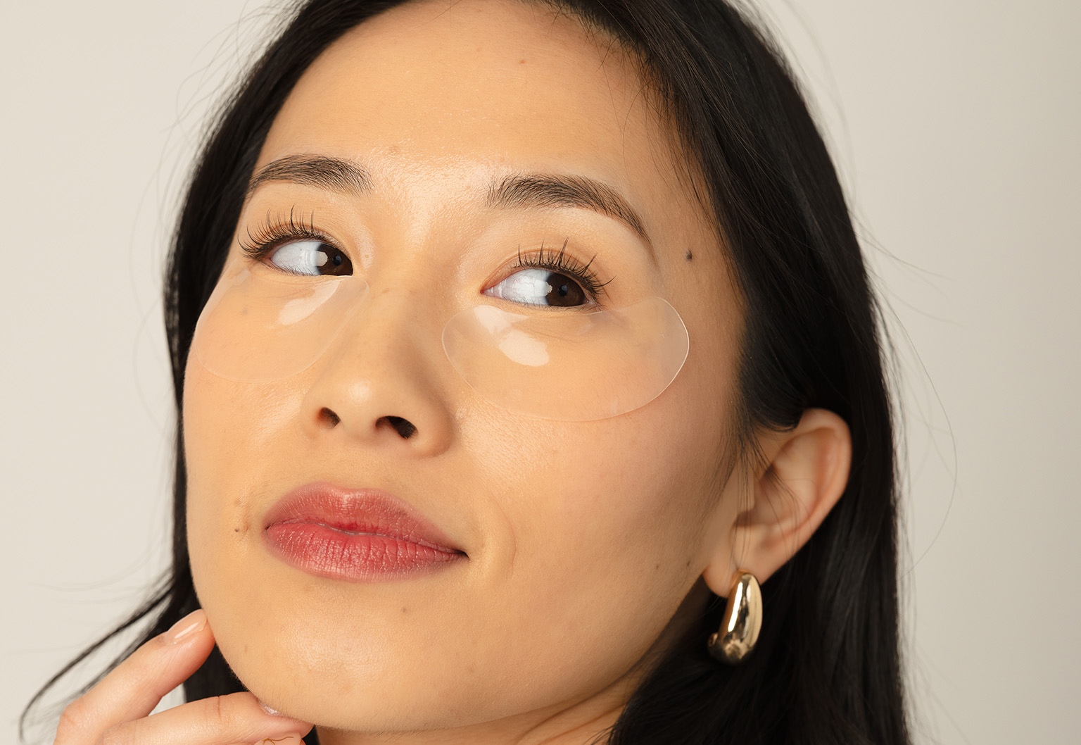 Woman receiving Gua Sha facial massage with stone tool.